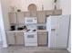 Well-equipped kitchen with white appliances, light wood cabinets, and ample counter space, perfect for cooking at 204 Birkdale St, Davenport, FL 33897