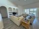 Bright and airy living room featuring built-in shelving, light gray flooring, and sliding glass doors to the pool deck at 204 Birkdale St, Davenport, FL 33897