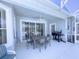 The covered patio features a ceiling fan, a dining table with seating, and a grill for outdoor cooking at 204 Birkdale St, Davenport, FL 33897