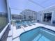 Lounge chairs line the screened-in pool and spa area, perfect for relaxing in the sun at 204 Birkdale St, Davenport, FL 33897