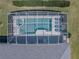 Aerial shot showcasing a sparkling screened-in pool and hot tub, surrounded by lounge chairs for relaxation at 204 Birkdale St, Davenport, FL 33897