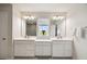 Bathroom featuring dual vanities, ample counter space, and well-lit mirrors at 2056 Airedale Way, Lake Alfred, FL 33850