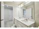 Bathroom showcasing a double vanity with white cabinets, a large mirror, and ample lighting at 2056 Airedale Way, Lake Alfred, FL 33850