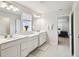 Bright bathroom featuring double sink vanity, neutral tile flooring and a view into the bedroom at 2056 Airedale Way, Lake Alfred, FL 33850