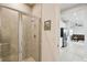 Shower with sliding glass door, neutral tile, and an adjacent hallway leading to the main living area at 2056 Airedale Way, Lake Alfred, FL 33850