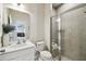 Well-lit bathroom with a glass-enclosed shower, white vanity, and neutral tile at 2056 Airedale Way, Lake Alfred, FL 33850