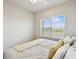 Cozy bedroom featuring a window with blinds, a comfortable bed, and soft, neutral decor at 2056 Airedale Way, Lake Alfred, FL 33850