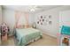 Whimsical bedroom featuring pink curtains, wall art, and a comfortable bed with decorative pillows at 2056 Airedale Way, Lake Alfred, FL 33850