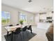 Bright dining area with a wooden table, black chairs, and sliding glass doors to the lanai at 2056 Airedale Way, Lake Alfred, FL 33850