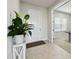 Bright entryway with a white front door, neutral tile flooring, and a view into an adjacent room at 2056 Airedale Way, Lake Alfred, FL 33850