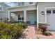 Inviting front porch with stone accents and a welcoming aqua-colored front door, enhanced by lush landscaping at 2056 Airedale Way, Lake Alfred, FL 33850