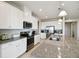 Bright kitchen features white cabinets, granite countertops, stainless steel appliances, and pendant lighting at 2056 Airedale Way, Lake Alfred, FL 33850