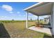 Covered patio with an outdoor dining set overlooking the spacious backyard at 2056 Airedale Way, Lake Alfred, FL 33850