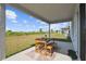 Covered patio featuring a wooden table, bench, and chairs overlooking the green backyard at 2056 Airedale Way, Lake Alfred, FL 33850