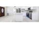 Bright kitchen features white cabinets, stainless steel appliances, a center island and sleek tile flooring at 226 Palmyra Dr, Orlando, FL 32807