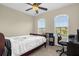 Bright bedroom featuring a ceiling fan, large windows, and a cozy bed with desk at 2261 Brookridge Trl, Sanford, FL 32773