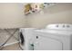 Functional laundry room with a washer, dryer, wire shelving, and an ironing board at 2261 Brookridge Trl, Sanford, FL 32773