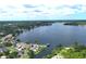 Expansive aerial view showcasing a scenic lake surrounded by lush greenery and beautiful residential properties at 235 S Shadowbay Blvd, Longwood, FL 32779