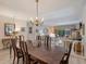 Well-lit dining area with chandelier, large wood table, and views into the spacious living room at 235 S Shadowbay Blvd, Longwood, FL 32779