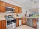 Efficient kitchen featuring stainless steel appliances, warm wood cabinets, and bright countertops at 235 S Shadowbay Blvd, Longwood, FL 32779