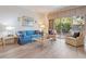 Relaxing living area with a comfortable blue sofa, neutral-toned armchairs, and sliding door access to the yard at 235 S Shadowbay Blvd, Longwood, FL 32779