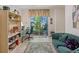Bright living area with sofa, desk and bookshelf next to a garden view at 235 S Shadowbay Blvd, Longwood, FL 32779