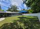 Expansive backyard with a screened-in pool area, a blue umbrella, and a white fence at 2417 Yale Ave, Sanford, FL 32771