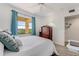 Bright bedroom featuring white walls, wood floors, and blue curtains framing the window at 2700 Ocean Shore Blvd # 515, Ormond Beach, FL 32176
