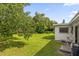 Well-maintained backyard with lush green grass and mature trees offers a serene outdoor space at 3016 Rogan Rd, Orlando, FL 32812