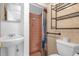 Cozy bathroom featuring a pedestal sink, tiled shower, and convenient storage shelf for added functionality at 3016 Rogan Rd, Orlando, FL 32812