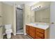 Well-lit bathroom features wood-look floors, wood vanity, white countertop and sleek glass enclosed shower at 3016 Rogan Rd, Orlando, FL 32812