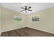 Bedroom features a ceiling fan, two windows, and stylish wood-look flooring at 3016 Rogan Rd, Orlando, FL 32812