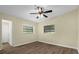 Bright bedroom featuring wood-look floors, a ceiling fan, and natural light from two windows at 3016 Rogan Rd, Orlando, FL 32812