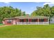Charming single story red brick home with a large covered front porch and a green lawn at 3016 Rogan Rd, Orlando, FL 32812
