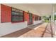 Inviting covered front porch featuring decorative metal window and door coverings on a red brick facade at 3016 Rogan Rd, Orlando, FL 32812
