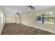 Spacious living room boasts wood-look flooring, neutral walls, a ceiling fan, and a view into the kitchen at 3016 Rogan Rd, Orlando, FL 32812
