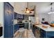 Modern kitchen with a stainless steel refrigerator, blue cabinets, and a peninsula with bar seating at 3237 Newmark Dr, Deltona, FL 32738