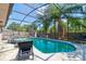 Screened-in pool area with patio furniture and lush tropical landscaping at 3237 Newmark Dr, Deltona, FL 32738