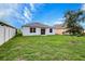 Well-maintained backyard with lush lawn, privacy fence and mature tree on a sunny day at 3354 Summerdale Way, Kissimmee, FL 34746
