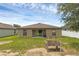 Backyard view showcasing the home's exterior, covered patio, and partially fenced yard at 340 Pheasant Dr, Haines City, FL 33844