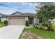Charming single-story home featuring a two-car garage and beautifully landscaped front yard with flowering tree at 340 Pheasant Dr, Haines City, FL 33844