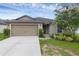 Charming single-story home featuring a two-car garage and beautifully landscaped front yard with flowering tree at 340 Pheasant Dr, Haines City, FL 33844