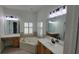 Bright bathroom with large mirrors, vanities, tub and shuttered windows at 340 Sorrento Rd, Kissimmee, FL 34759