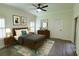 Modern bedroom showcases a ceiling fan, framed art, and dresser with a round mirror at 340 Sorrento Rd, Kissimmee, FL 34759