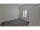 Bedroom featuring neutral walls, gray carpet, and shuttered window with light at 340 Sorrento Rd, Kissimmee, FL 34759