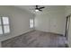 Well-lit bedroom with fan, gray carpet, shuttered windows, and a door at 340 Sorrento Rd, Kissimmee, FL 34759