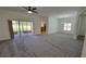 Spacious living room featuring neutral walls, carpeted flooring, and sliding doors leading to a screened patio at 340 Sorrento Rd, Kissimmee, FL 34759