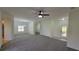 Spacious open-plan living area with neutral carpeting, abundant natural light, and a ceiling fan at 340 Sorrento Rd, Kissimmee, FL 34759