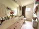 Bright bathroom featuring a vanity with double sinks, tile floors and shower with a shower curtain at 3539 Maple Ridge Loop, Kissimmee, FL 34741