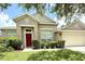 Charming single-story home featuring a red front door and well-maintained landscaping at 3539 Maple Ridge Loop, Kissimmee, FL 34741